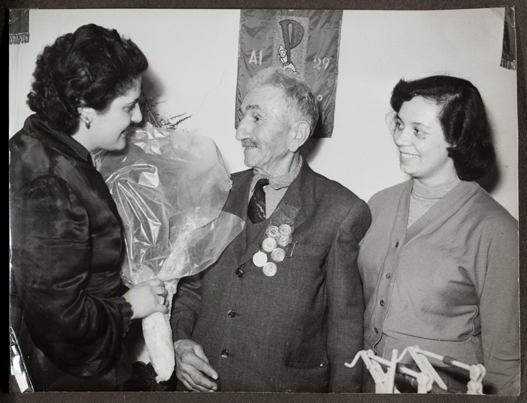 Sede bolognese del Partito Socialista Italiano (?), Alcide Cervi in visita riceve in omaggio un mazzo di garofani